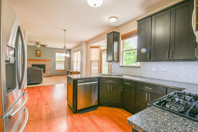 1804 Westbrook Ct, Plainfield, IL 60586 - kitchen with appliances with stainless steel finishes, a sink, a brick fireplace, ceiling fan, and backsplash