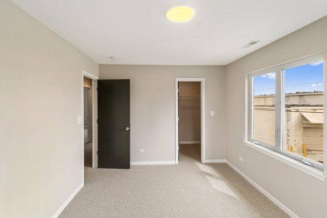 22429 Karlov Ave, Richton Park, IL 60471 - unfurnished bedroom with baseboards, light carpet, a spacious closet, and a closet