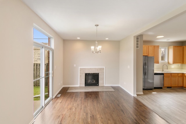 22429 Karlov Ave, Richton Park, IL 60471 - unfurnished living room featuring wood finished floors, baseboards, recessed lighting, a chandelier, and a sink