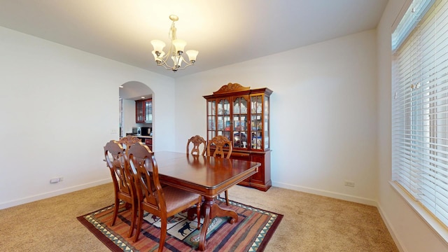 731 W Kenilworth Ave, Palatine, IL 60067 - dining room with arched walkways, light colored carpet, a chandelier, and baseboards