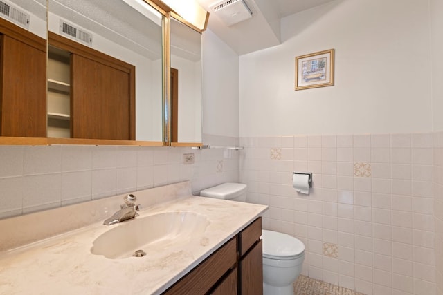 6950 W Forest Preserve Dr Unit 215, Norridge, IL 60706 - bathroom with toilet, vanity, tile walls, and wainscoting