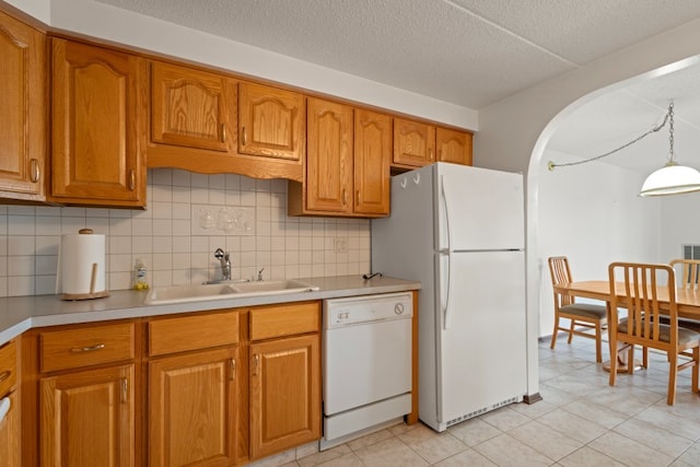 6950 W Forest Preserve Dr Unit 215, Norridge, IL 60706 - kitchen with white appliances, a sink, brown cabinets, decorative backsplash, and a textured ceiling