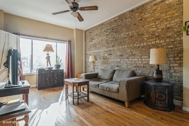 1418 N Campbell Ave, Chicago, IL 60622 - living room with wood-type flooring, a ceiling fan, baseboards, a wood stove, and brick wall