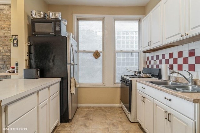 1418 N Campbell Ave, Chicago, IL 60622 - kitchen with gas range oven, black microwave, a sink, tasteful backsplash, and white cabinetry