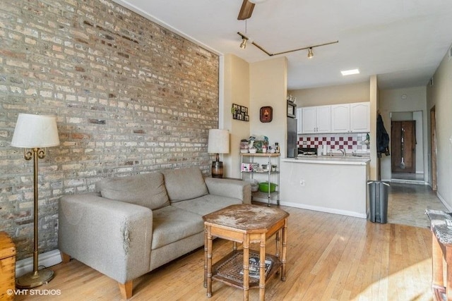 1418 N Campbell Ave, Chicago, IL 60622 - living area with light wood finished floors, rail lighting, baseboards, and brick wall