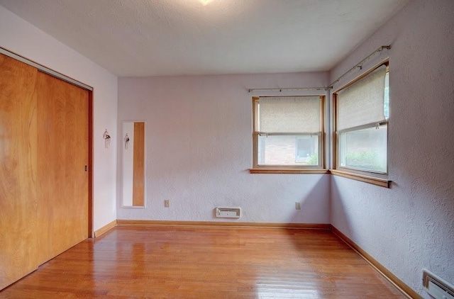 908 Catherine St, Joliet, IL 60435 - spare room featuring wood finished floors, baseboards, and a textured wall
