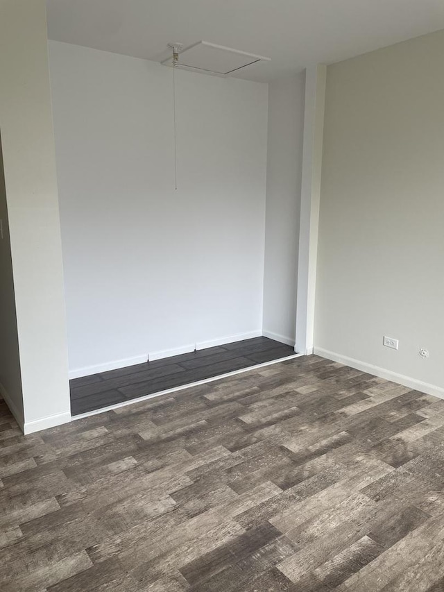 unfurnished room with attic access and wood finished floors