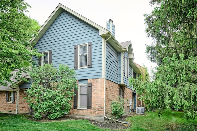 202 Country Ln Unit 202, Des Plaines, IL 60016 - view of property exterior featuring a chimney, brick siding, a yard, and central air condition unit