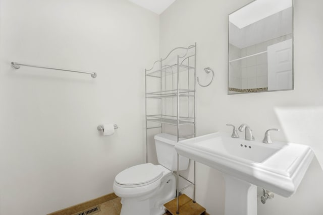 1157 W 19th Pl, Chicago, IL 60608 - bathroom with toilet, a sink, a shower, tile patterned flooring, and baseboards