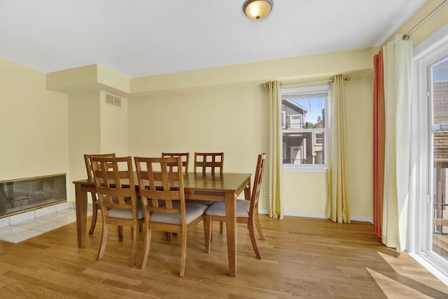 1157 W 19th Pl, Chicago, IL 60608 - dining space featuring light wood-style floors, baseboards, and a multi sided fireplace