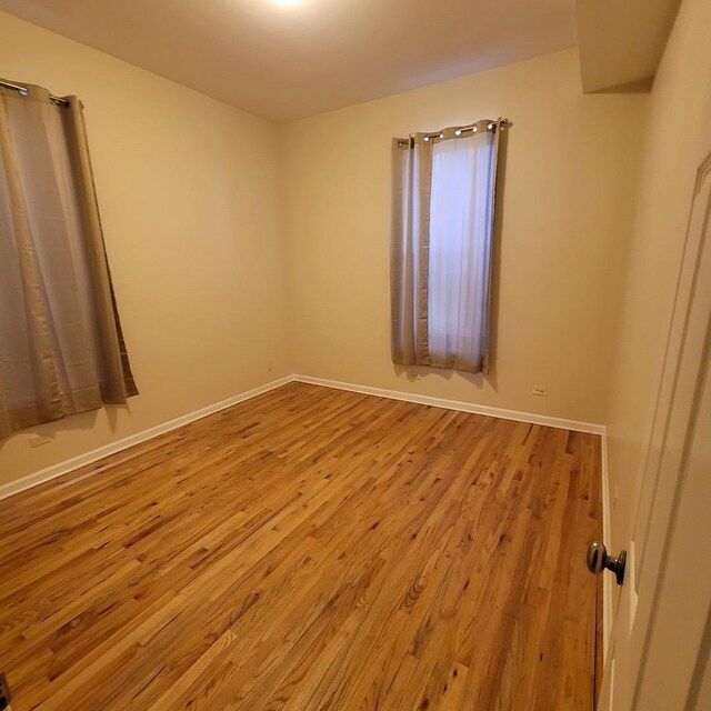 6033 S Prairie Ave, Chicago, IL 60637 - spare room with wood finished floors and baseboards