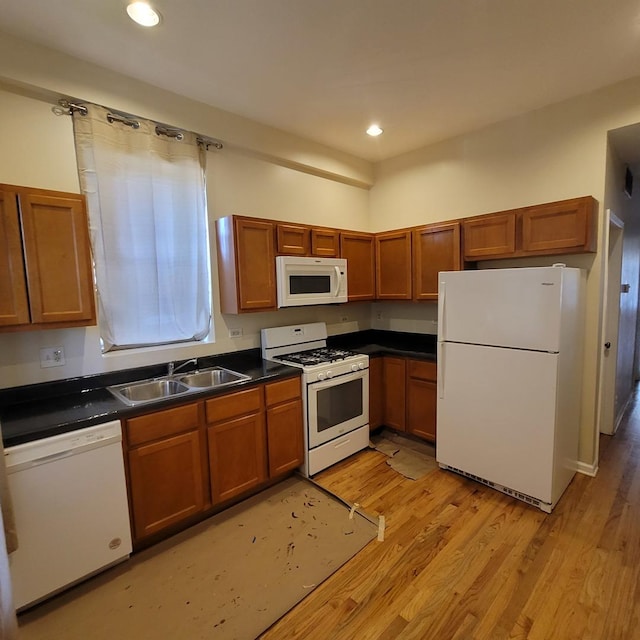 6033 S Prairie Ave, Chicago, IL 60637 - kitchen with white appliances, a sink, dark countertops, light wood finished floors, and brown cabinetry