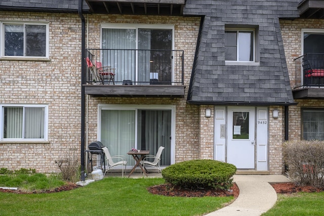 9452 Bay Colony Dr Unit 2W, Des Plaines, IL 60016 - view of exterior entry featuring a balcony and brick siding