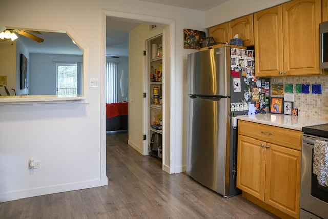 9452 Bay Colony Dr Unit 2W, Des Plaines, IL 60016 - kitchen with appliances with stainless steel finishes, a ceiling fan, decorative backsplash, dark wood finished floors, and light countertops