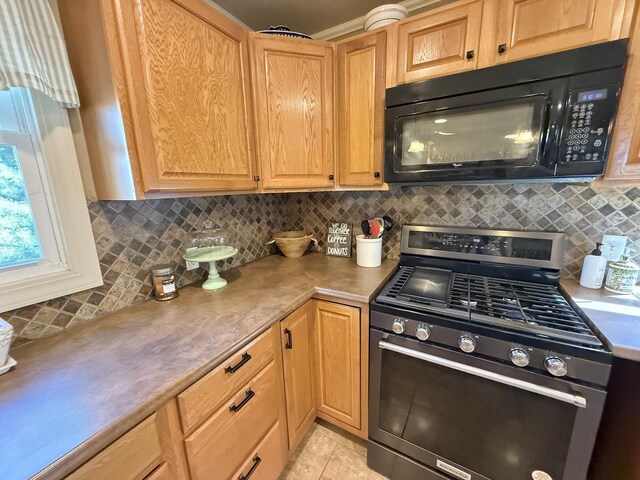 202 17th Ave, Sterling, IL 61081 - kitchen with black microwave, stainless steel gas stove, decorative backsplash, light countertops, and light tile patterned floors