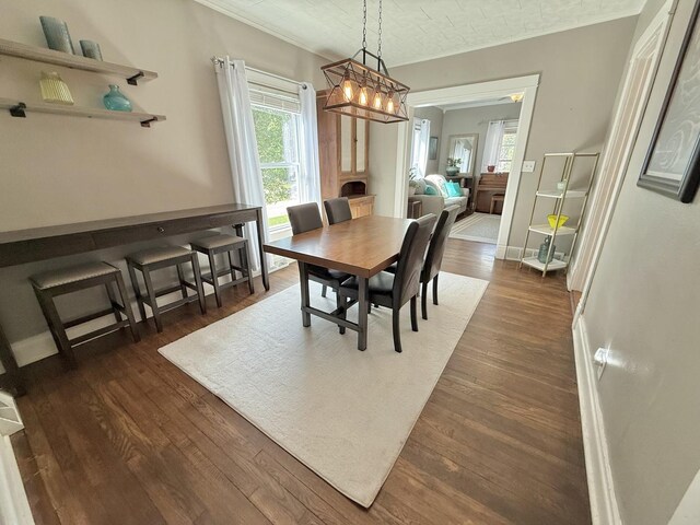 202 17th Ave, Sterling, IL 61081 - dining space with crown molding, dark wood finished floors, baseboards, and a chandelier