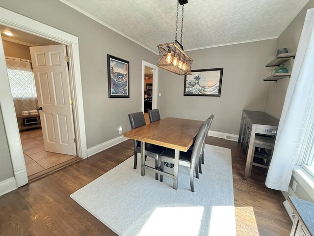 202 17th Ave, Sterling, IL 61081 - dining room featuring baseboards, crown molding, and dark wood-style floors