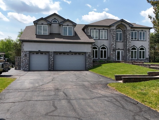 18609 Pinon Trl, Marengo, IL 60152 - view of front facade with stucco siding, asphalt driveway, stone siding, a front lawn, and roof with shingles