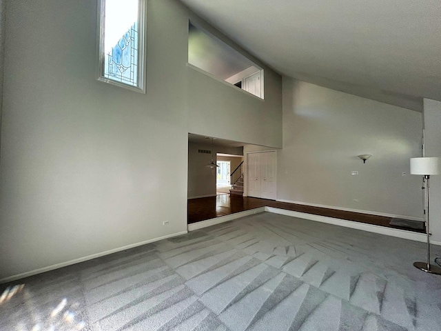 1622 Indian Knoll Rd, Naperville, IL 60565 - unfurnished living room featuring carpet, baseboards, high vaulted ceiling, and stairway