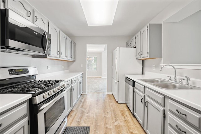 30W014 Willow Ln Unit 1, Warrenville, IL 60555 - kitchen featuring appliances with stainless steel finishes, a sink, light wood-style flooring, light countertops, and baseboards