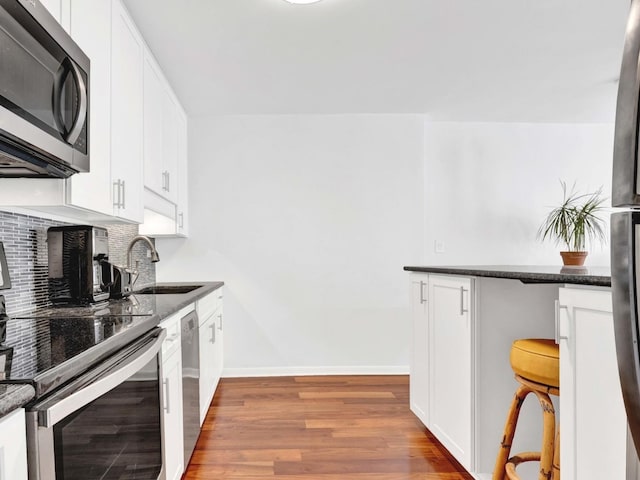 5455 N Sheridan Rd Unit 2206, Chicago, IL 60640 - kitchen featuring appliances with stainless steel finishes, a sink, baseboards, light wood-style floors, and backsplash