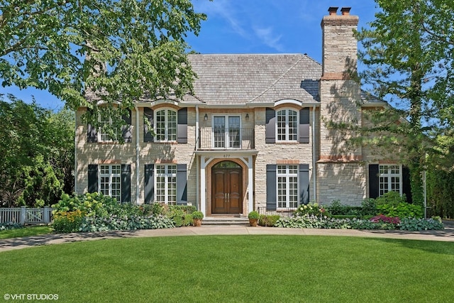 677 Greenleaf Ave, Glencoe, IL 60022 - view of front of property with a chimney, stone siding, and a high end roof