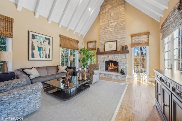 677 Greenleaf Ave, Glencoe, IL 60022 - living room featuring high vaulted ceiling, healthy amount of natural light, light wood-style flooring, a stone fireplace, and beam ceiling