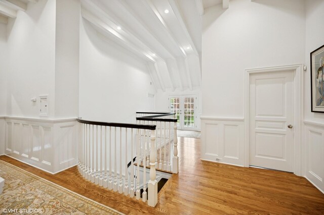 677 Greenleaf Ave, Glencoe, IL 60022 - corridor featuring an upstairs landing, wood finished floors, wainscoting, lofted ceiling, and a decorative wall