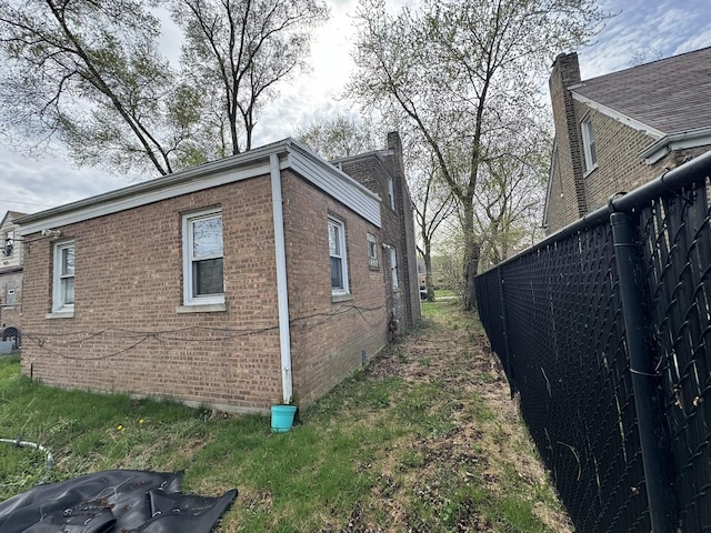10035 S Yates Blvd, Chicago, IL 60617 - view of side of home featuring brick siding and a chimney