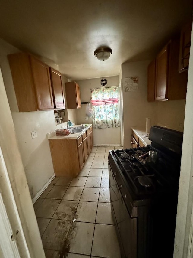 10035 S Yates Blvd, Chicago, IL 60617 - kitchen with range with gas stovetop, brown cabinetry, light tile patterned floors, a sink, and light countertops