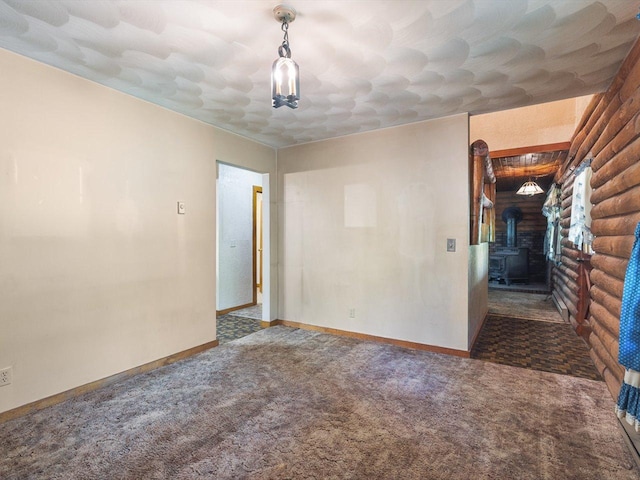 5123 Walnut Gove, Poplar Grove, IL 61065 - spare room featuring a wood stove, carpet floors, baseboards, and rustic walls