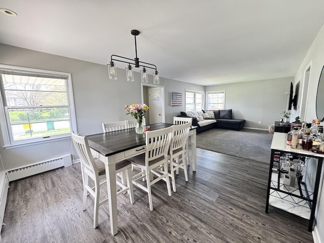 1128 Somonauk St, Sycamore, IL 60178 - dining area featuring baseboard heating, dark wood-type flooring, baseboards, and a chandelier