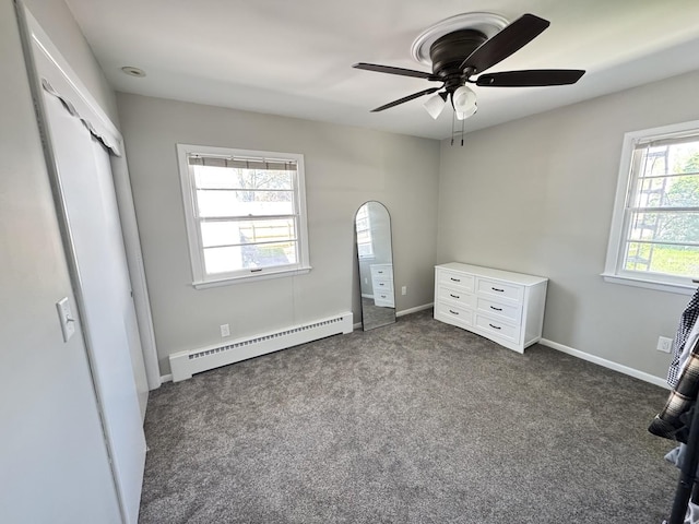 1128 Somonauk St, Sycamore, IL 60178 - unfurnished bedroom featuring baseboard heating, dark colored carpet, ceiling fan, and baseboards