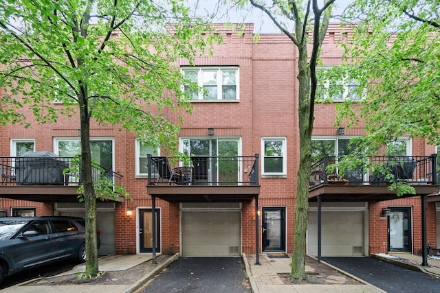 2803 N Wolcott Ave Unit D, Chicago, IL 60657 - view of front facade featuring a garage, brick siding, and driveway