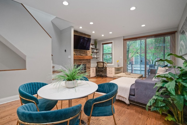 2803 N Wolcott Ave Unit D, Chicago, IL 60657 - dining room with a stone fireplace, recessed lighting, baseboards, and light wood-style floors