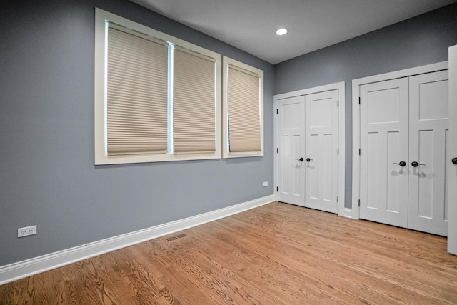 2803 N Wolcott Ave Unit D, Chicago, IL 60657 - unfurnished bedroom with multiple closets, baseboards, light wood finished floors, and recessed lighting