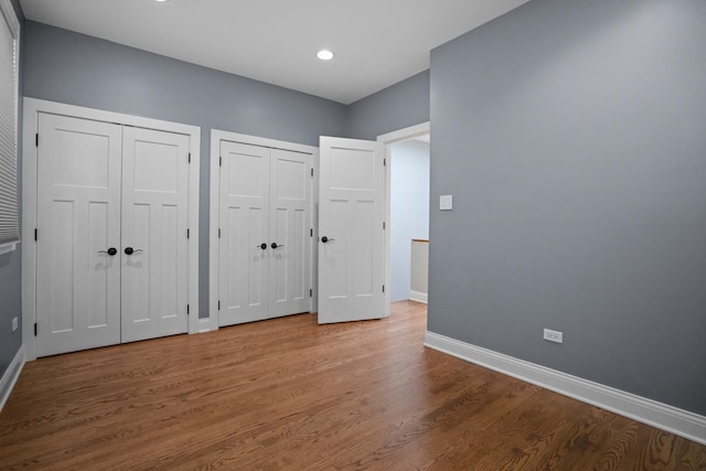 2803 N Wolcott Ave Unit D, Chicago, IL 60657 - unfurnished bedroom featuring two closets, baseboards, wood finished floors, and recessed lighting
