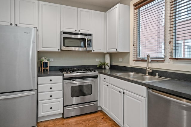 2803 N Wolcott Ave Unit D, Chicago, IL 60657 - kitchen featuring stainless steel appliances, a sink, white cabinets, and dark countertops