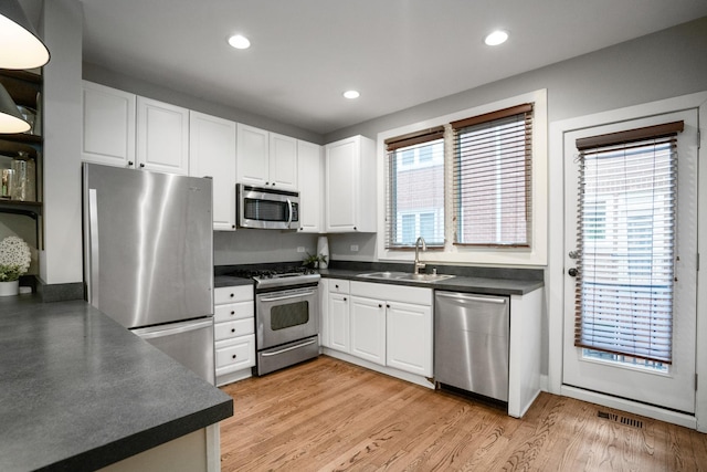 2803 N Wolcott Ave Unit D, Chicago, IL 60657 - kitchen featuring appliances with stainless steel finishes, a sink, dark countertops, white cabinets, and recessed lighting