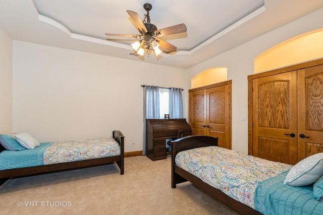 10944 Arbor Ridge Dr, Orland Park, IL 60467 - bedroom featuring a tray ceiling, light carpet, a ceiling fan, and multiple closets
