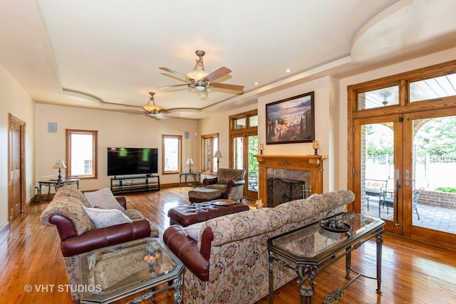 10944 Arbor Ridge Dr, Orland Park, IL 60467 - living room featuring a raised ceiling, ceiling fan, wood-type flooring, a fireplace, and french doors