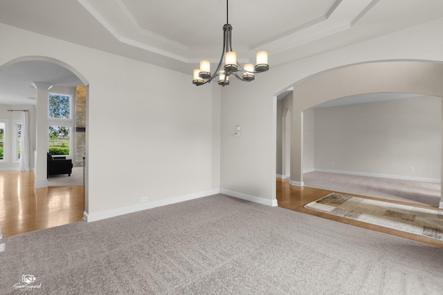 491 Bloomfield Cir W, Oswego, IL 60543 - carpeted empty room with arched walkways, a raised ceiling, a chandelier, and baseboards