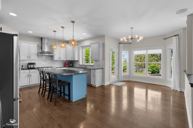 491 Bloomfield Cir W, Oswego, IL 60543 - kitchen featuring wall chimney exhaust hood, freestanding refrigerator, a sink, dark countertops, and a chandelier