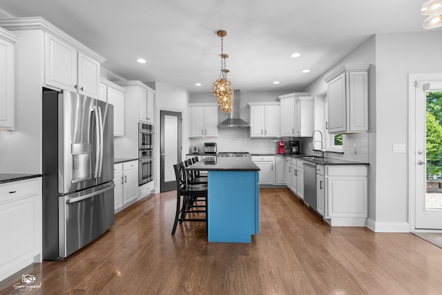 491 Bloomfield Cir W, Oswego, IL 60543 - kitchen with appliances with stainless steel finishes, dark countertops, wall chimney range hood, dark wood finished floors, and tasteful backsplash