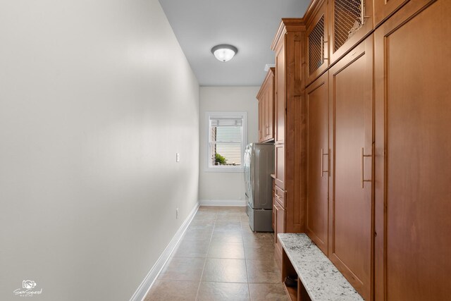 491 Bloomfield Cir W, Oswego, IL 60543 - hallway featuring washer and dryer, baseboards, and light tile patterned flooring