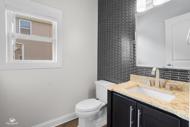 491 Bloomfield Cir W, Oswego, IL 60543 - bathroom with vanity, toilet, backsplash, baseboards, and wood finished floors