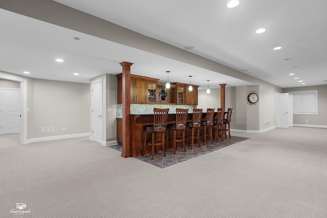491 Bloomfield Cir W, Oswego, IL 60543 - kitchen featuring light colored carpet, baseboards, a kitchen bar, glass insert cabinets, and recessed lighting
