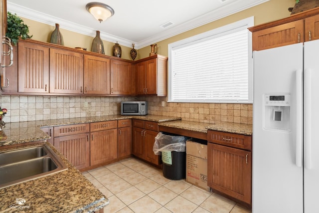491 Bloomfield Cir W, Oswego, IL 60543 - kitchen with white fridge with ice dispenser, stainless steel microwave, backsplash, light tile patterned floors, and crown molding