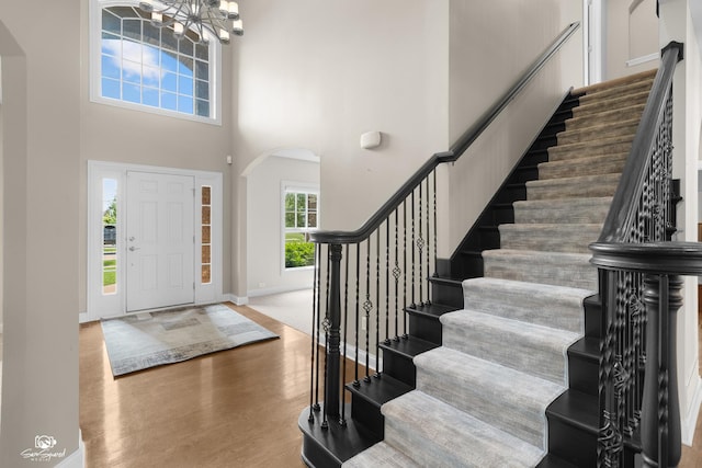 491 Bloomfield Cir W, Oswego, IL 60543 - foyer featuring arched walkways, stairs, wood finished floors, a chandelier, and a high ceiling