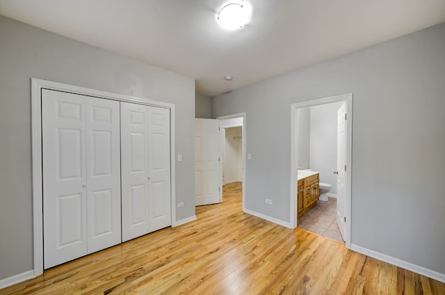 947 W 51st St, Chicago, IL 60609 - unfurnished bedroom featuring light wood finished floors, a closet, ensuite bathroom, and baseboards